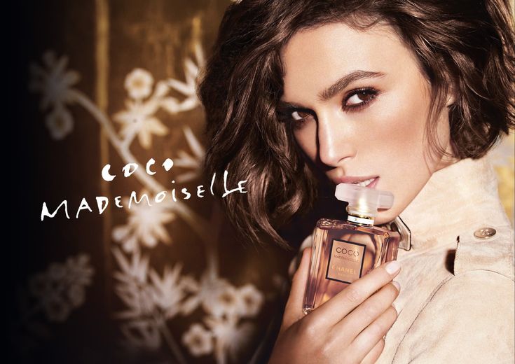 Woman holding a perfume bottle with 'Coco Mademoiselle' text